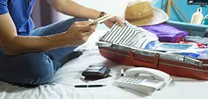 Caribbean Man sitting on bed using mobile phone