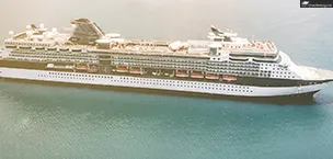 Celebrity_Cruise_Tips A large cruise ship sailing in the ocean, with clear blue water and a bright sky in the background