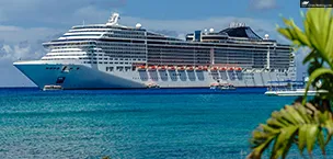 First_Time_Cruisers A Large Cruise Ship Docked in Clear Turquoise Waters on a Sunny Day with Small Boats Nearby