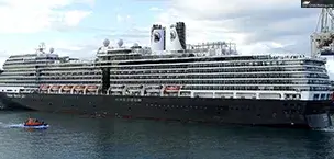 Large cruise ship on ocean with small boat nearby