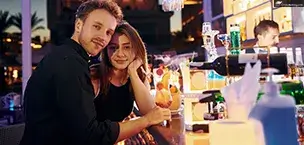A happy young couple is on vacation at a bar