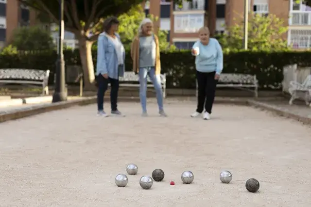 A group of elderly friends playing petanque together