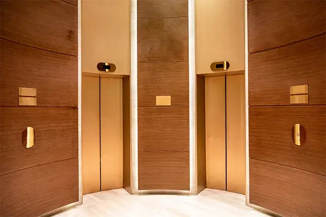 Doors of the elevator are closed. Curved wooden interior in contemporary style