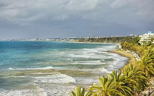 The Marbella beach and stormy sea are seen in a panoramic view