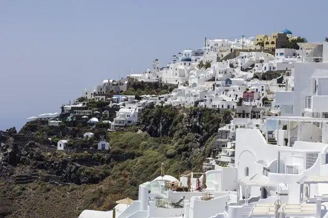 An aerial view of the town of Oia with its white houses and windmills, located on the island of Santorini in Greece