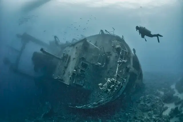 A shipwreck is explored underwater