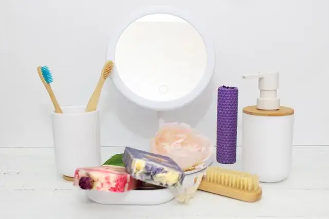 In a blue bathroom, soap and toiletries are arranged on a shelf