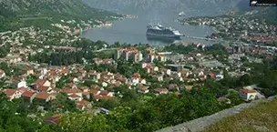 Docked cruise ship with a city view and mountains